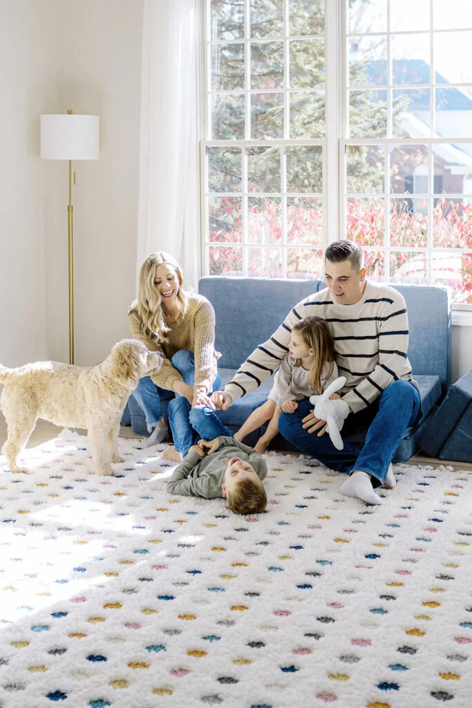 family laughing together with their dog